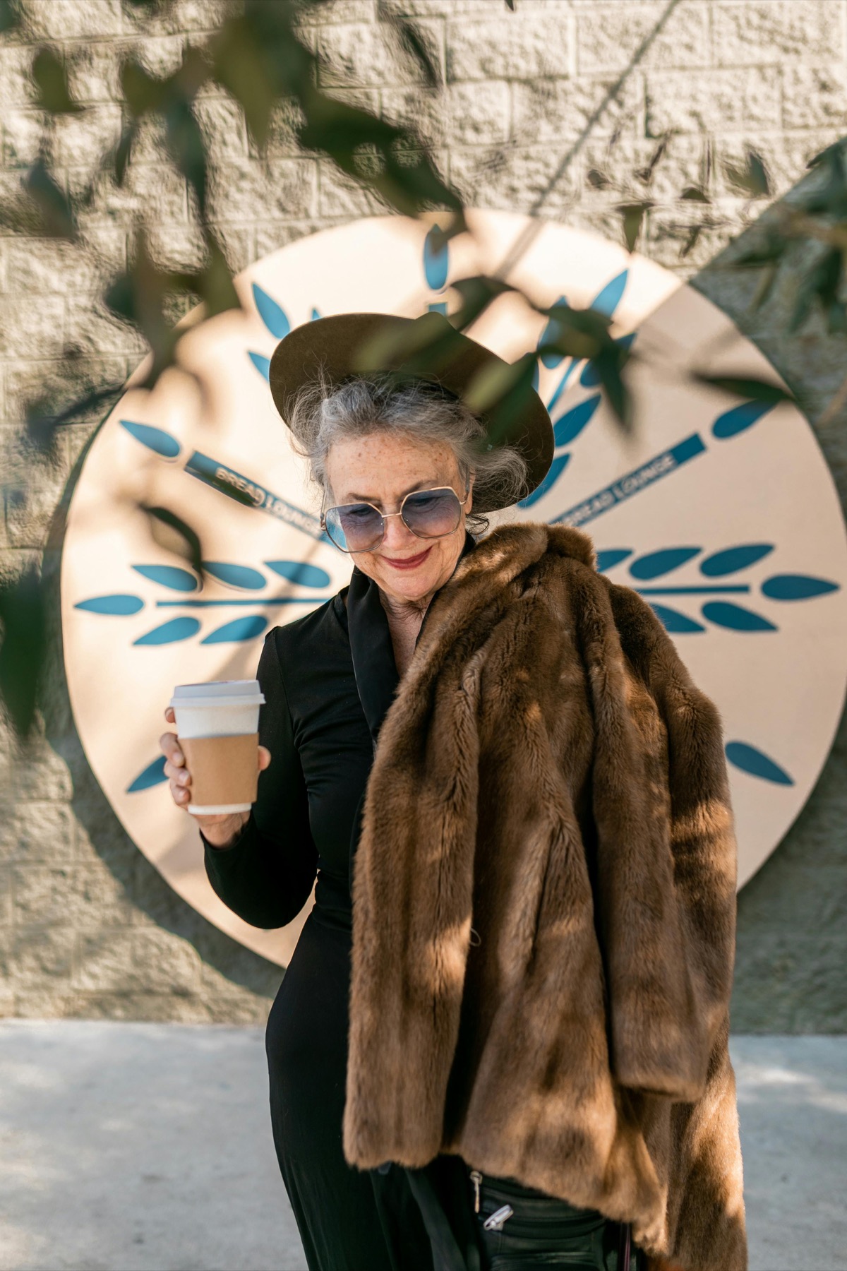 Femme âgée élégante tenant un manteau de fourrure